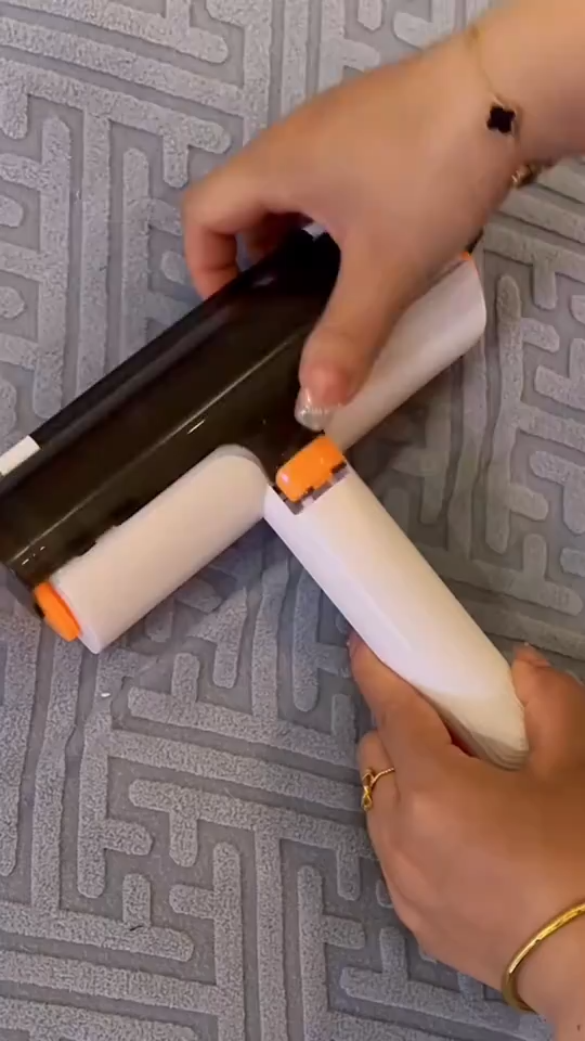 White and orange roller held against upholstery, with the collection cover open